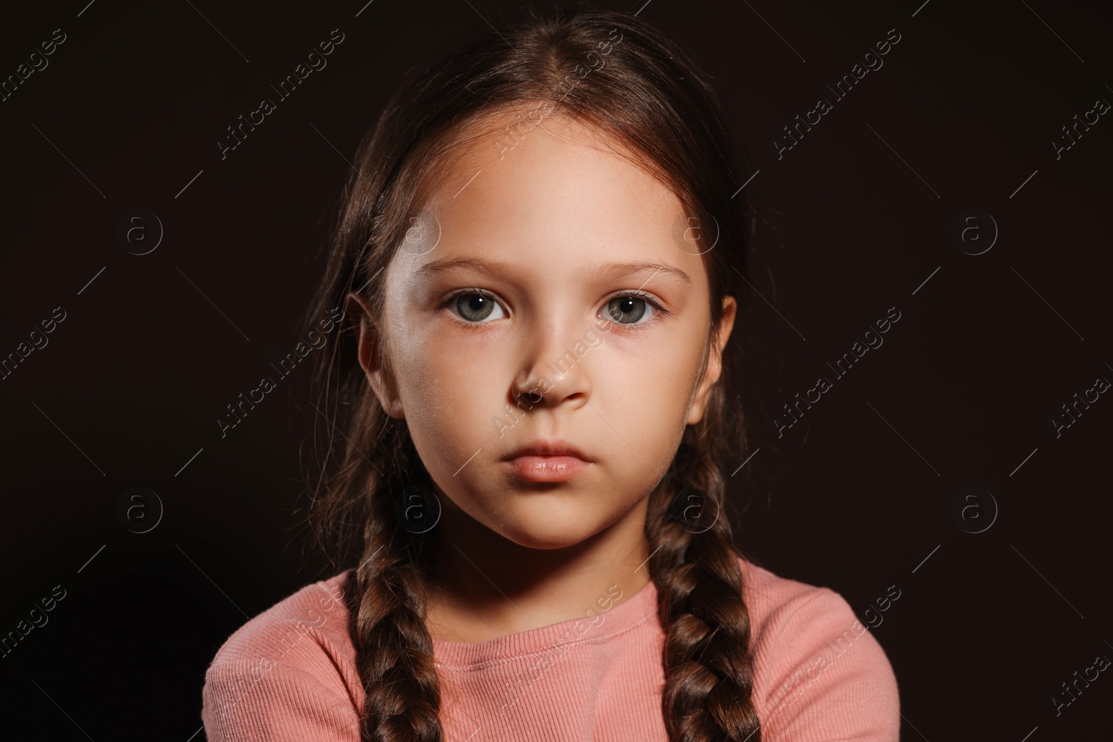 Photo of Orphanage concept. Sad girl on black background