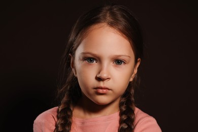 Photo of Orphanage concept. Sad girl on black background