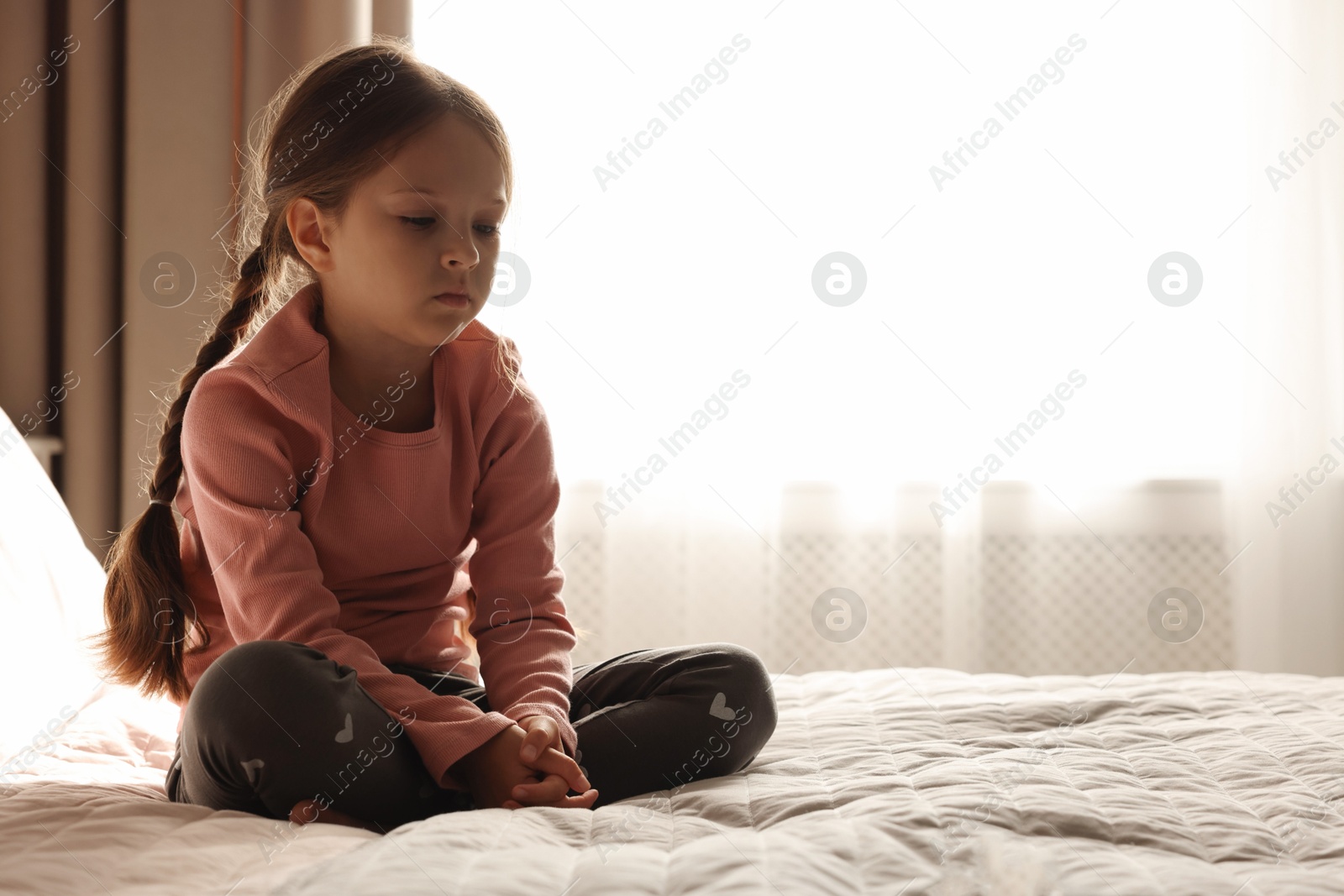 Photo of Orphanage concept. Sad girl on bed in room