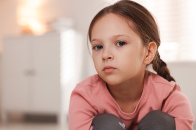 Photo of Orphanage concept. Portrait of sad girl in room