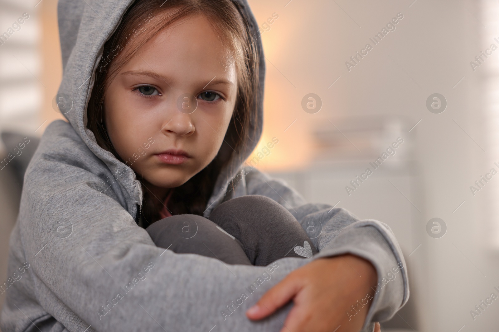 Photo of Orphanage concept. Portrait of sad girl in room