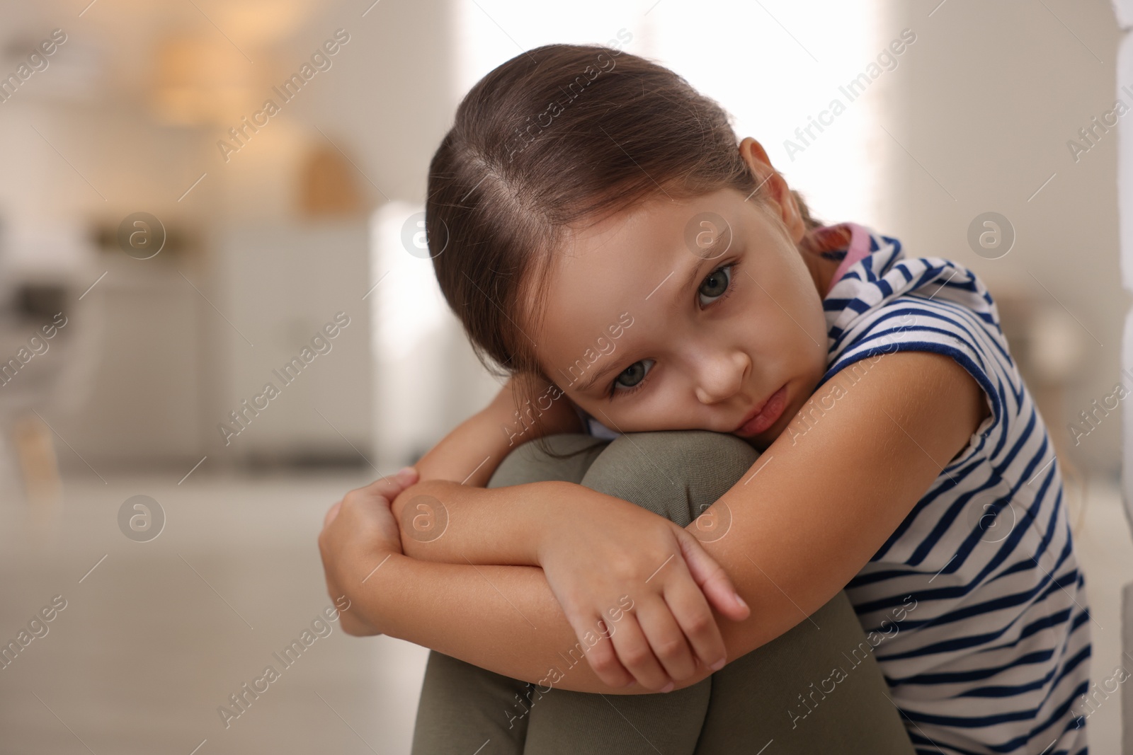 Photo of Orphanage concept. Portrait of sad girl in room