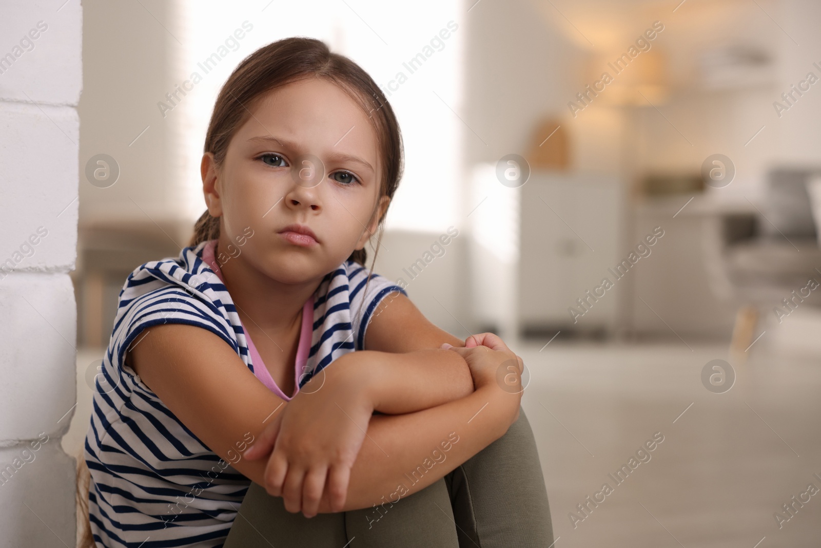 Photo of Orphanage concept. Portrait of sad girl in room