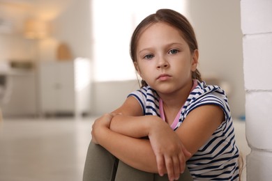 Photo of Orphanage concept. Portrait of sad girl in room