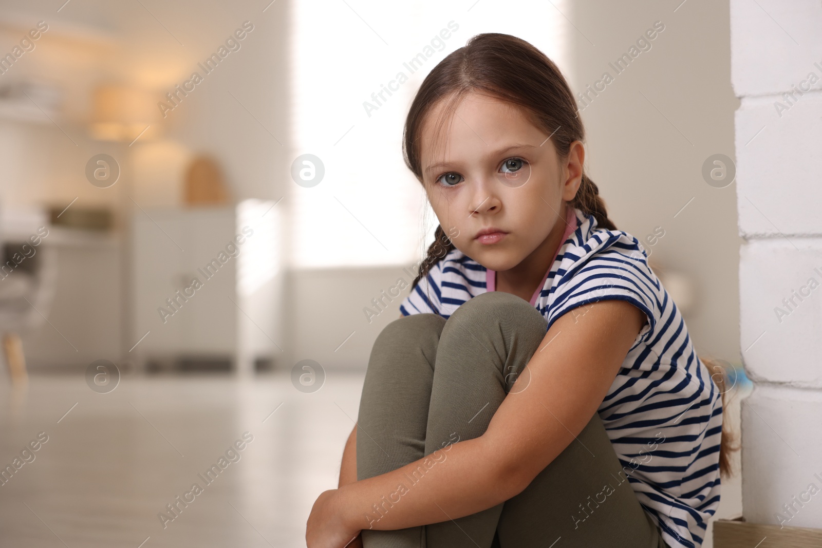 Photo of Orphanage concept. Portrait of sad girl in room