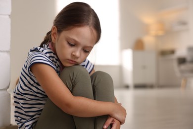 Photo of Orphanage concept. Portrait of sad girl in room