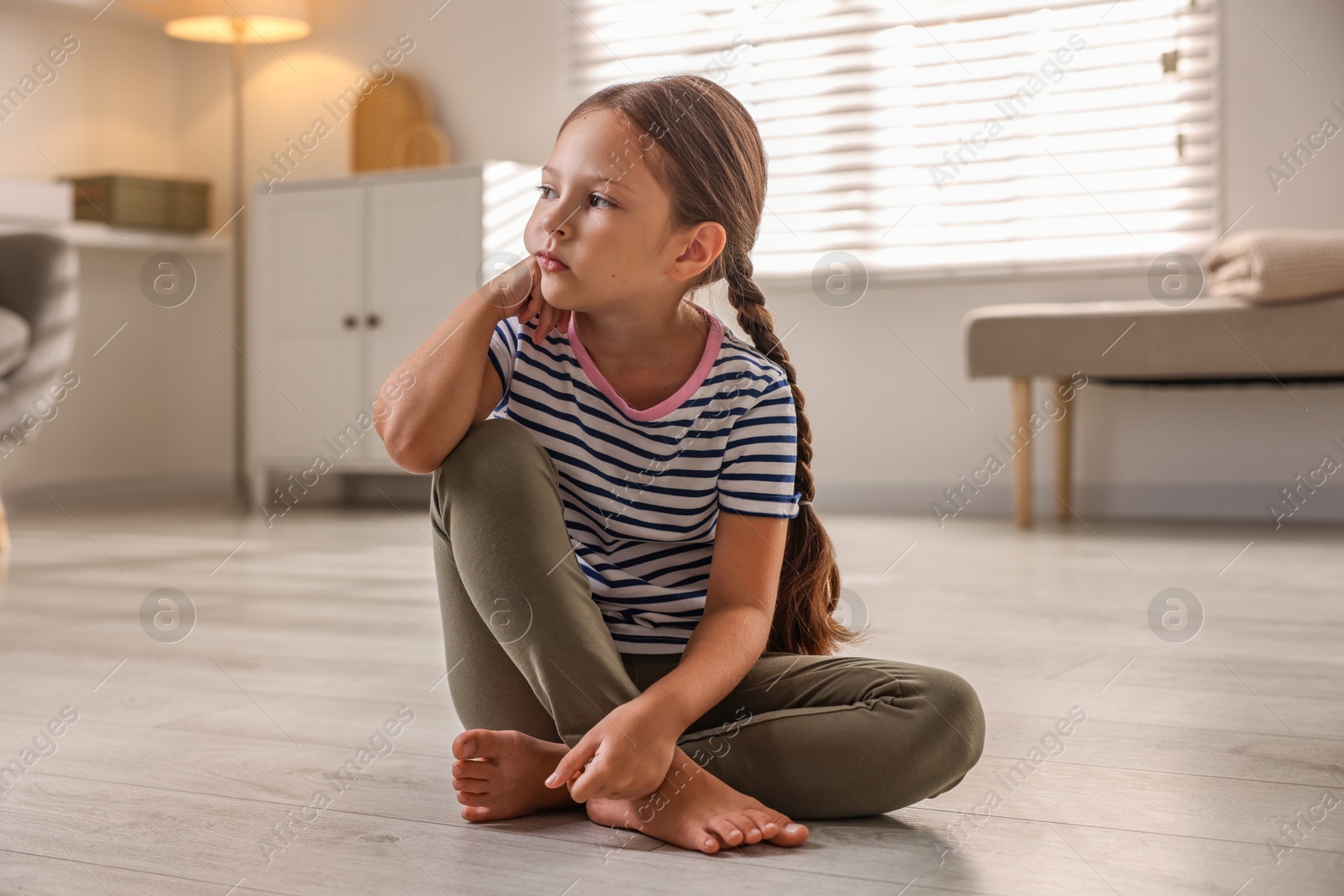 Photo of Orphanage concept. Sad girl sitting on floor indoors