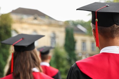 Photo of Students at graduation ceremony outdoors, back view