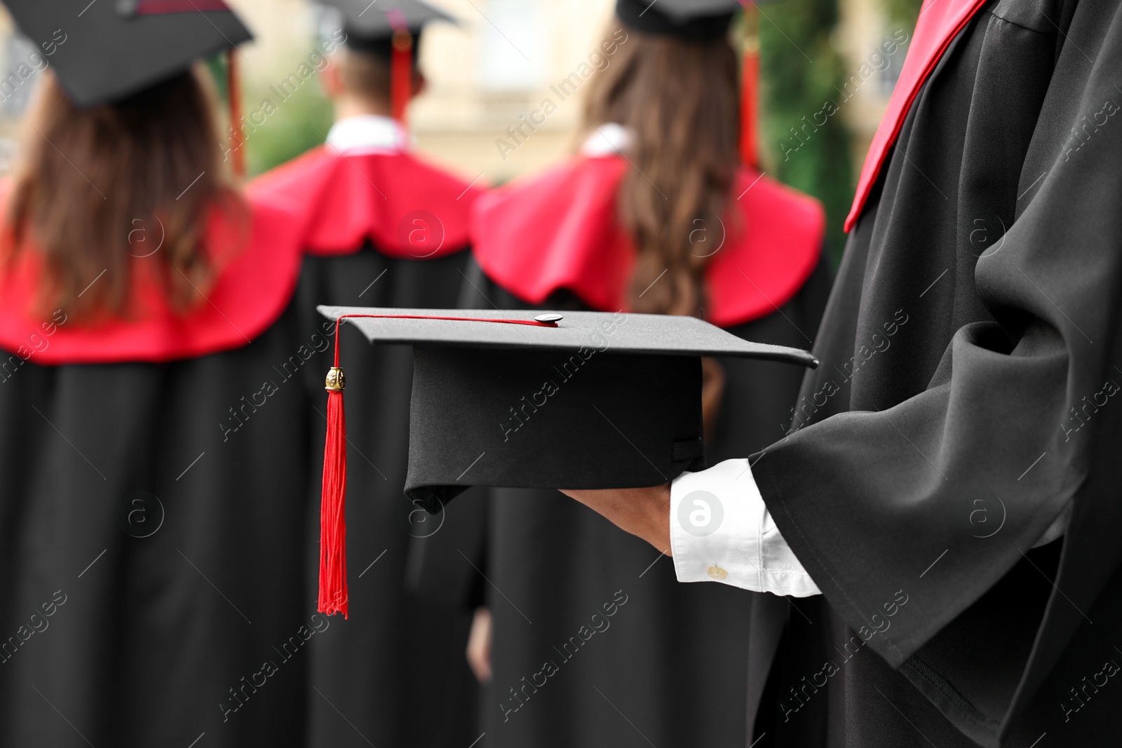 Photo of Student with graduation hat at ceremony outdoors, selective focus