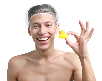 Photo of Happy man in shower cap with bath duck on white background