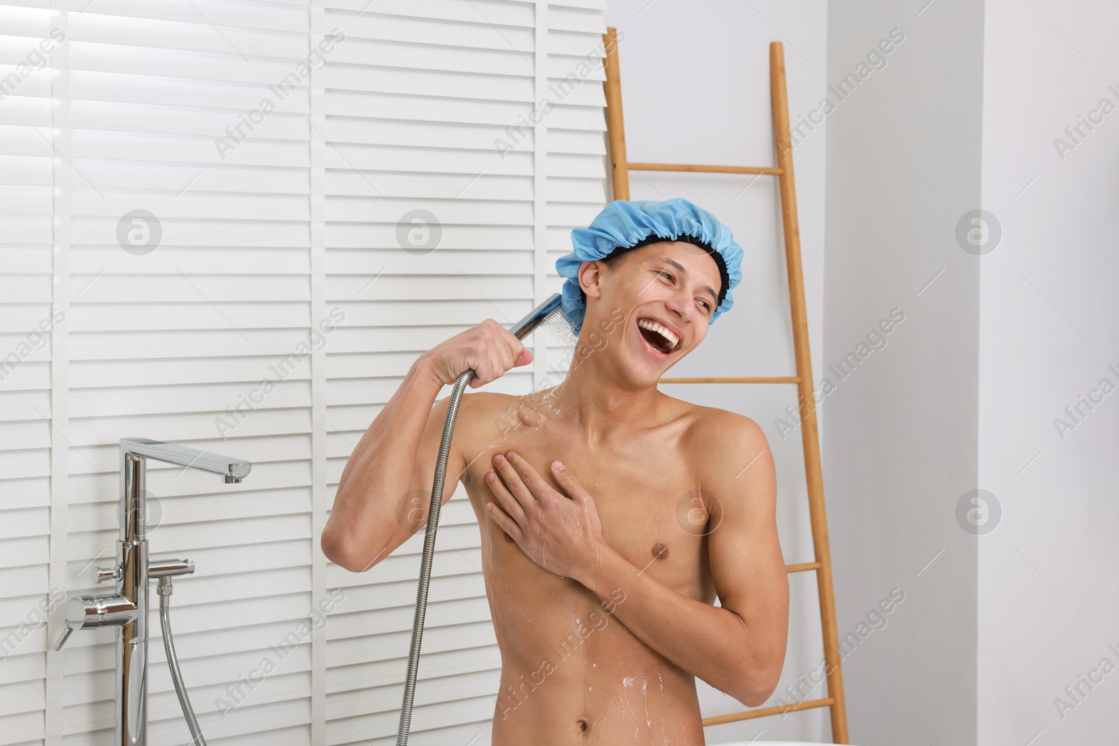 Photo of Man with cap taking shower in bathroom