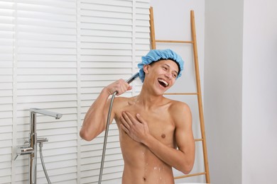 Man with cap taking shower in bathroom