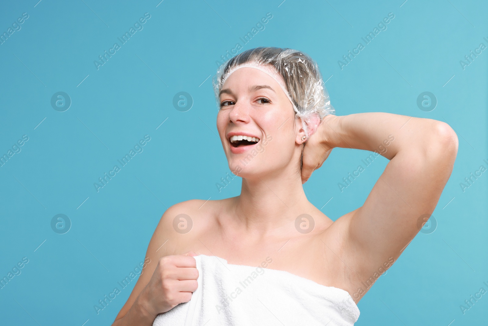 Photo of Woman in shower cap on light blue background