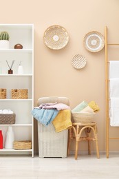 Photo of Wicker basket full of laundry, detergents and toiletries in bathroom