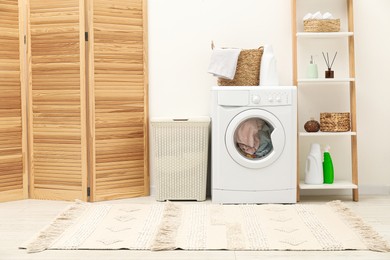 Photo of Wicker laundry baskets, washing machine and detergent in bathroom