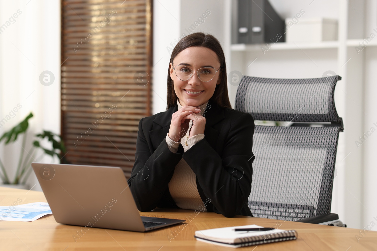 Photo of Businesswoman with glasses at table in office