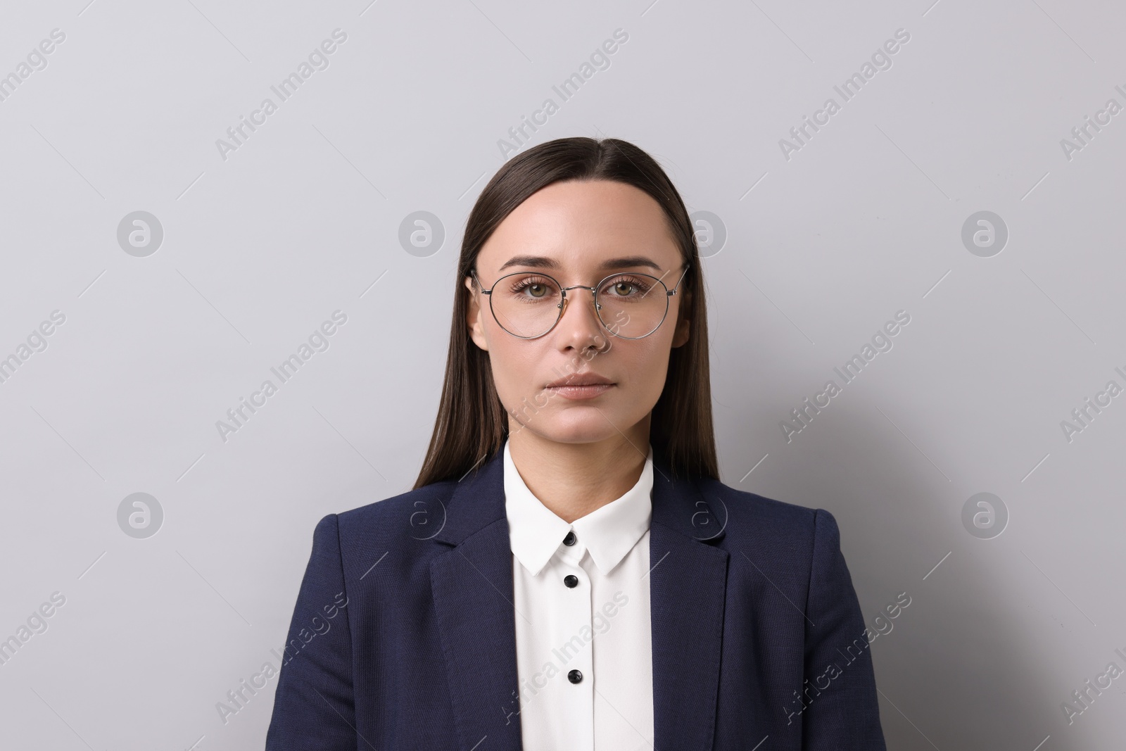 Photo of Portrait of businesswoman in glasses on light grey background