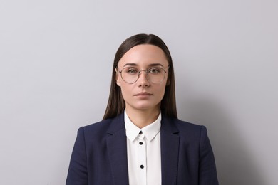 Portrait of businesswoman in glasses on light grey background