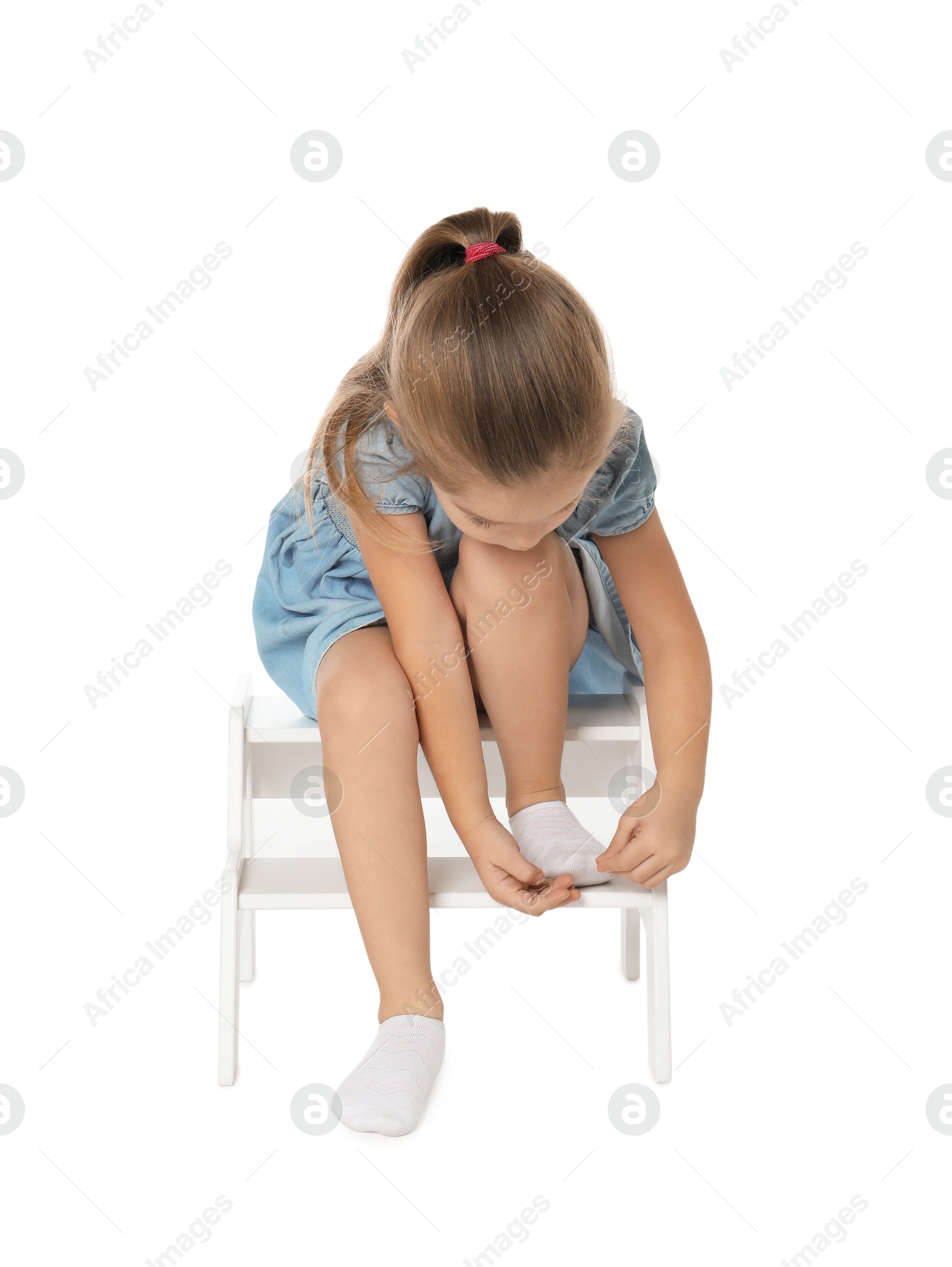 Photo of Little girl with step stool on white background