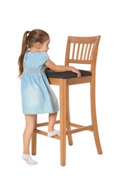 Photo of Little girl standing on stool against white background