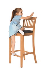 Photo of Little girl standing on stool against white background