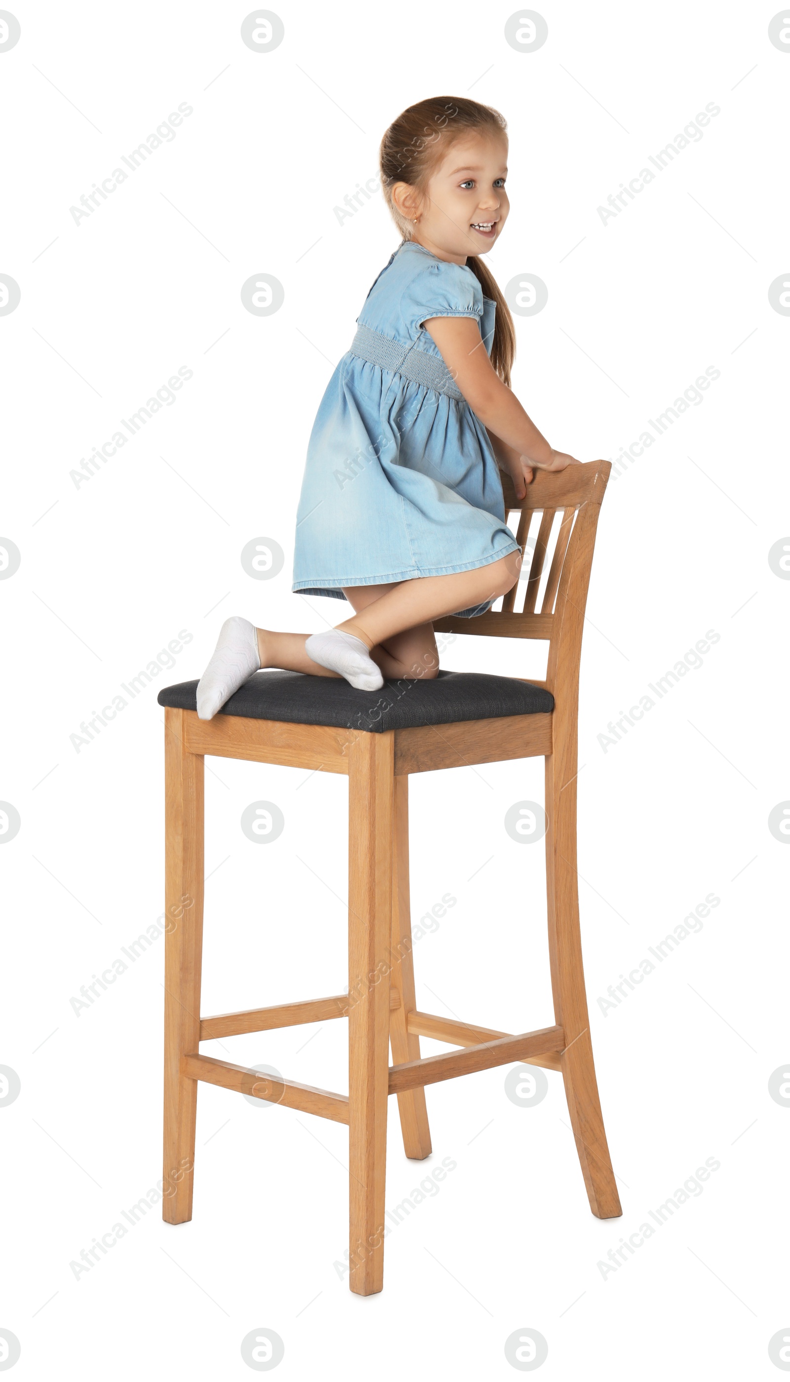 Photo of Little girl sitting on stool against white background