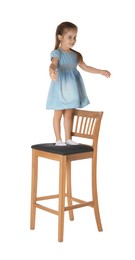 Photo of Little girl standing on stool against white background