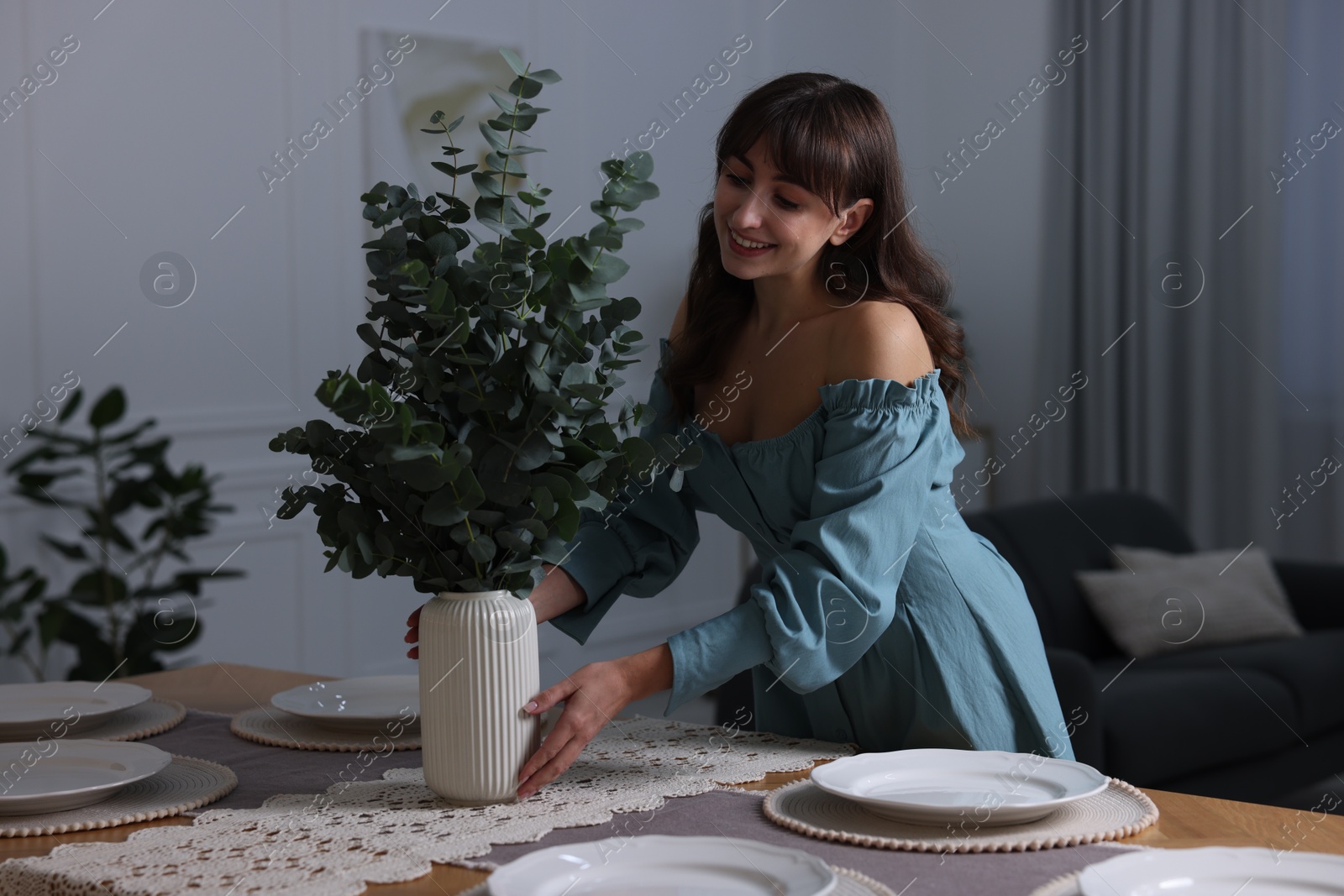 Photo of Woman setting table for dinner at home