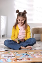 Photo of Creating vision board. Girl cutting out picture on floor indoors