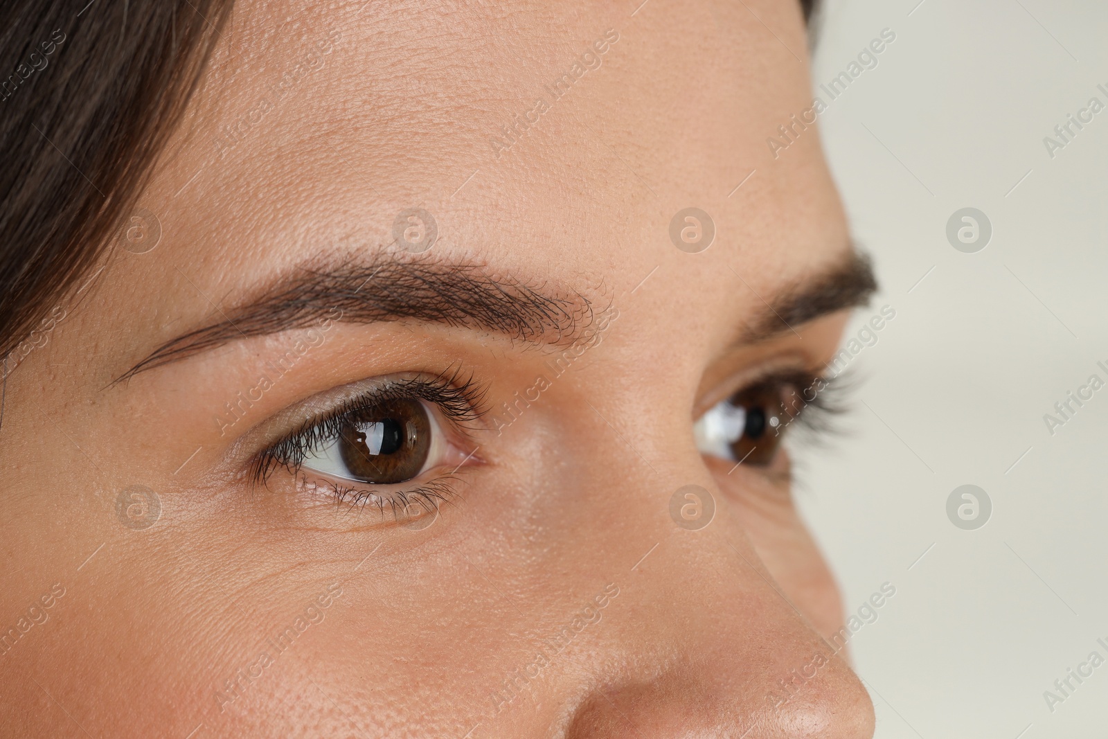 Photo of Woman with beautiful eyes on light background, closeup