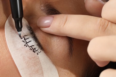 Photo of Esthetician mapping under eye patch before lash extensions procedure, closeup