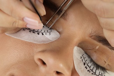 Photo of Young woman undergoing lash extensions procedure, closeup