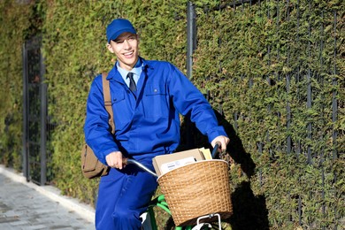 Photo of Postman with parcels in bicycle basket outdoors