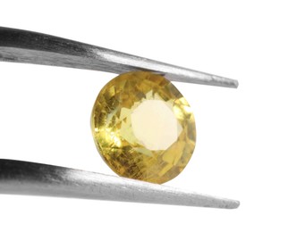 Photo of Tweezers with shiny yellow gemstone isolated on white