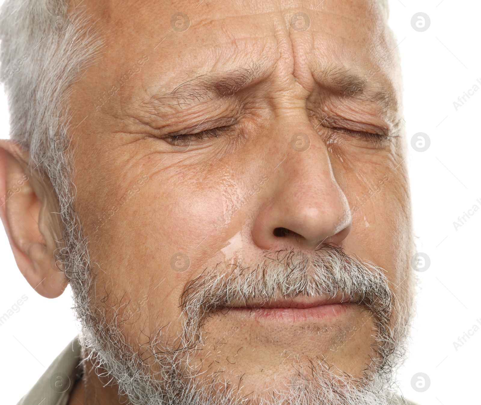 Photo of Sad senior man crying on white background, closeup