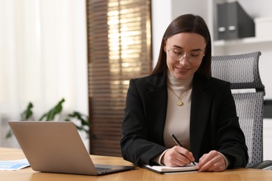 Photo of Businesswoman working at wooden table in office