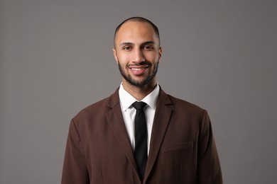 Portrait of businessman in brown jacket on gray background