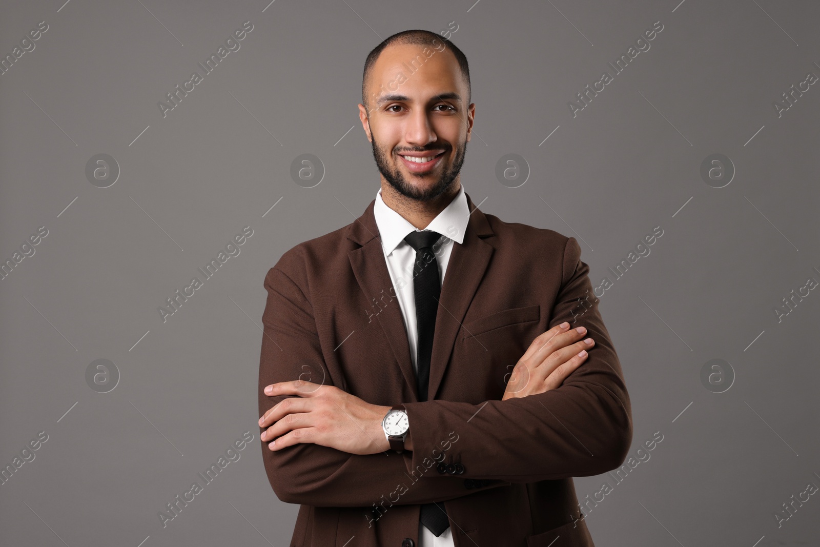 Photo of Portrait of businessman in brown jacket on gray background