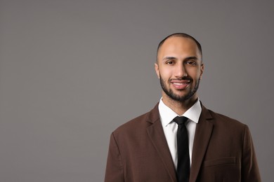 Photo of Portrait of businessman in brown jacket on gray background, space for text