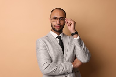 Portrait of businessman in glasses on beige background