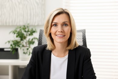 Photo of Portrait of happy businesswoman in jacket indoors