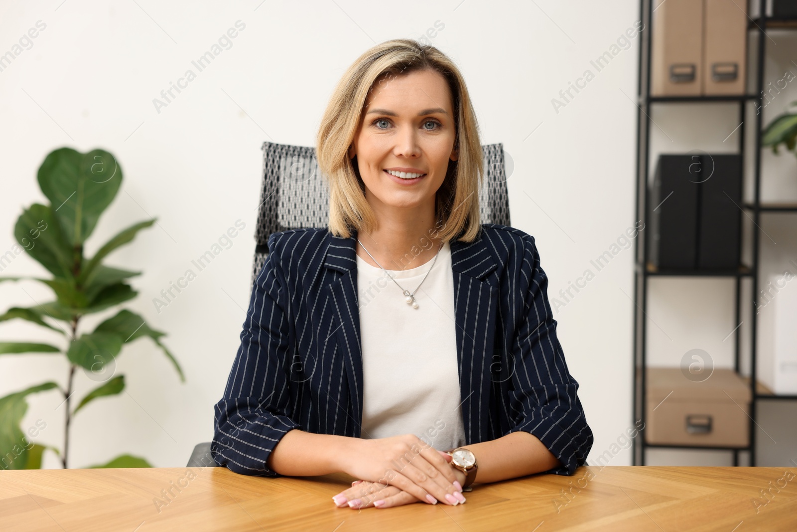 Photo of Portrait of happy businesswoman at table in office