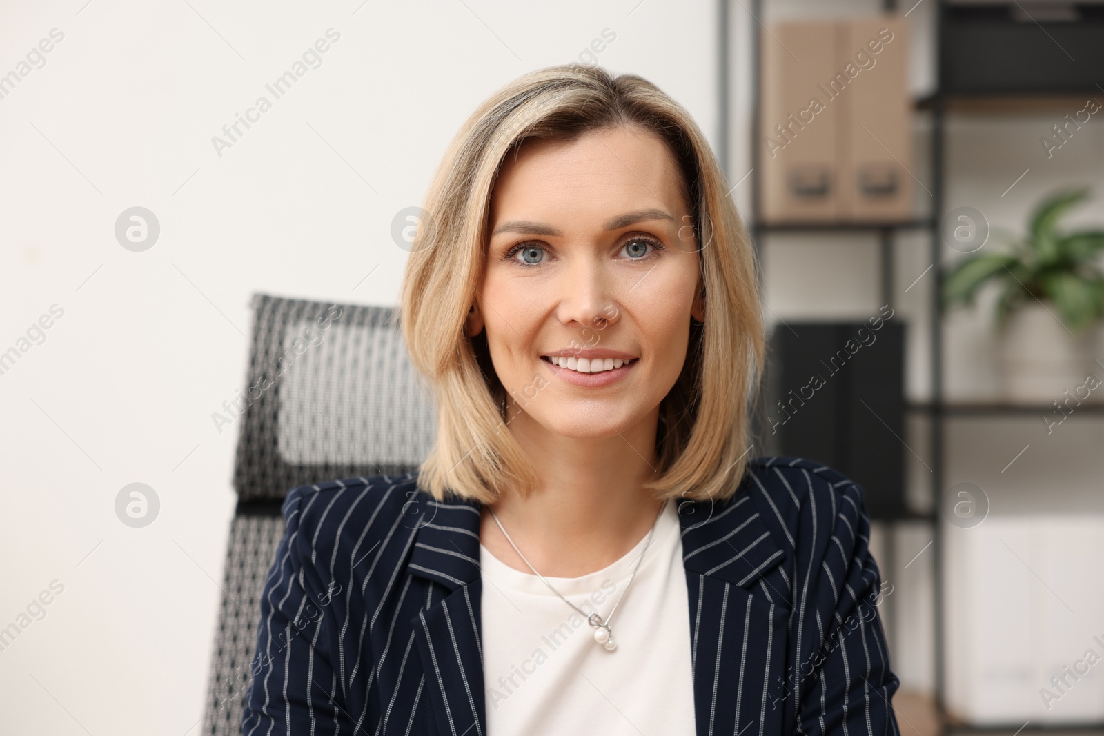 Photo of Portrait of happy businesswoman in jacket indoors