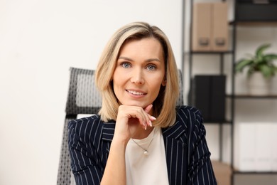 Portrait of happy businesswoman in jacket indoors