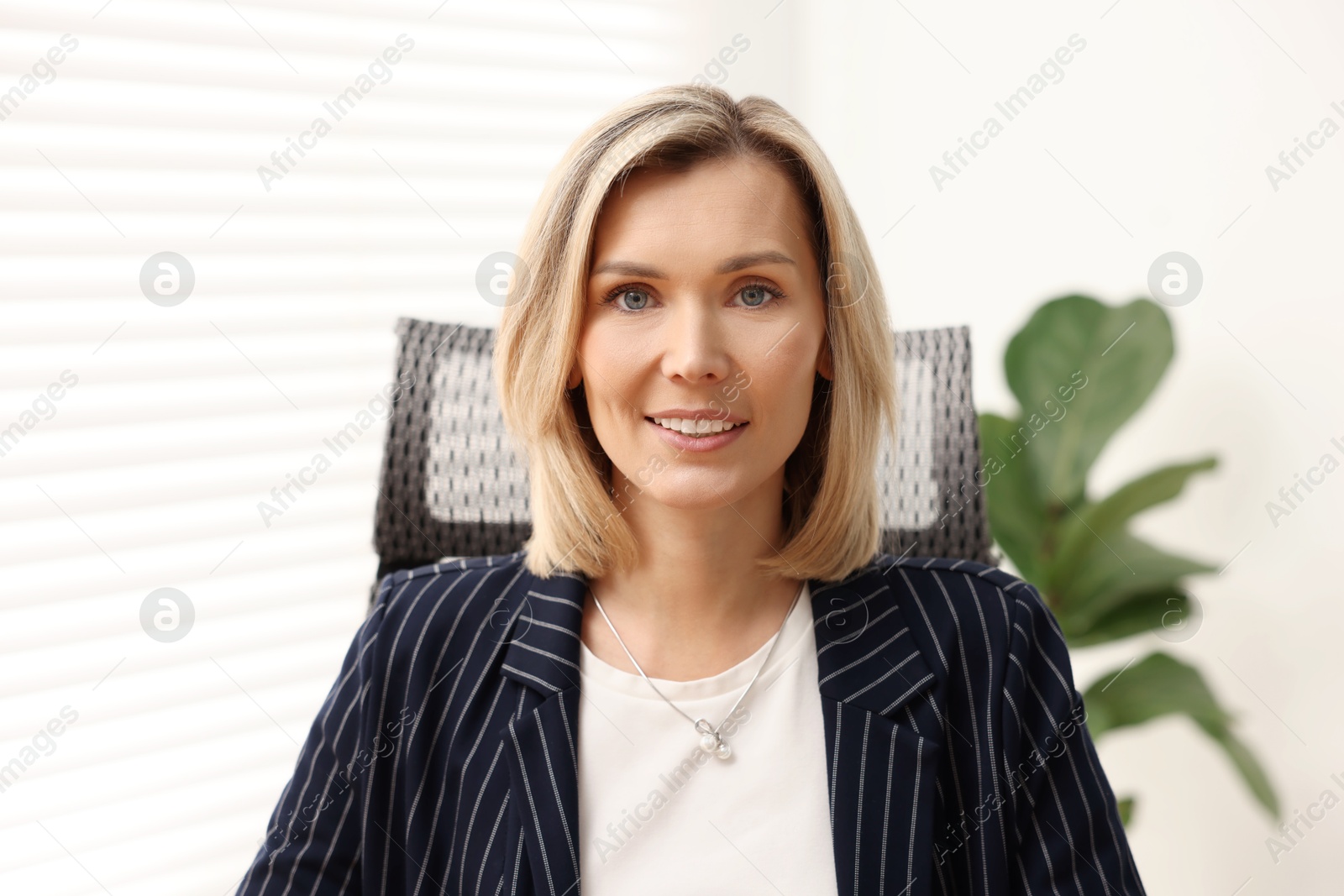 Photo of Portrait of happy businesswoman in jacket indoors