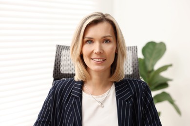 Photo of Portrait of happy businesswoman in jacket indoors