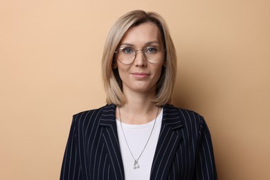 Photo of Portrait of businesswoman in glasses on beige background