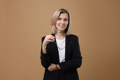 Photo of Portrait of businesswoman with glasses on beige background