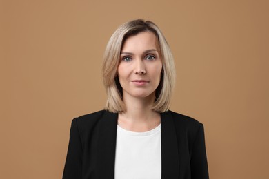 Photo of Portrait of businesswoman in jacket on beige background