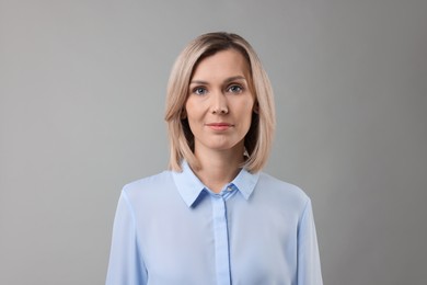 Photo of Portrait of businesswoman in light blue shirt on gray background